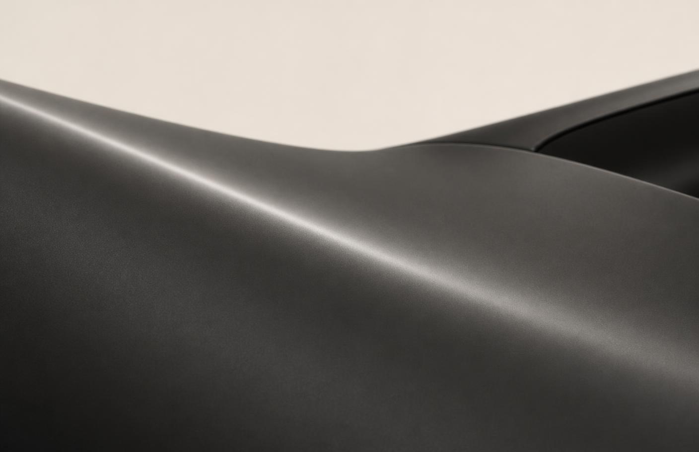Close study of light travelling across a matte graphite car body panel